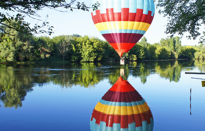 hot air balloon ride in dordogne, the balloon is by the river